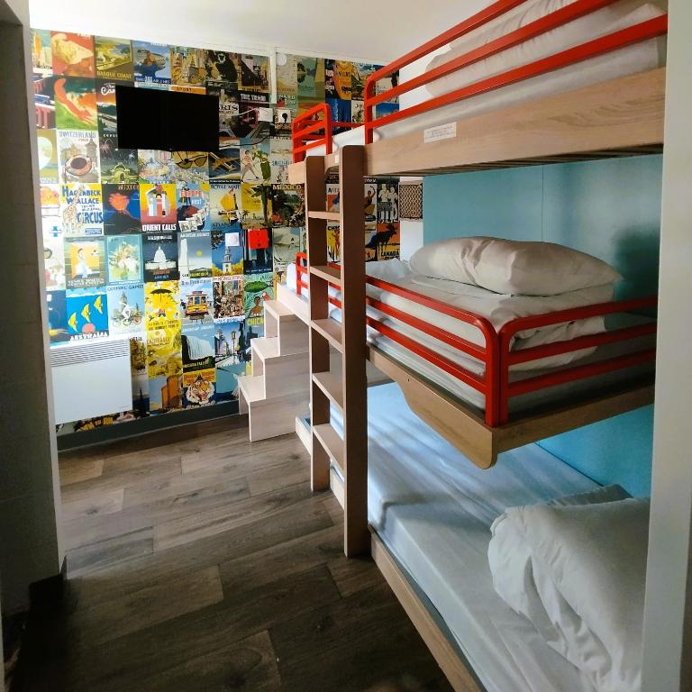 a room with bunk beds and a tv on a wall at hotelF1 Lyon Bourgoin-Jallieu in LʼIsle-dʼAbeau