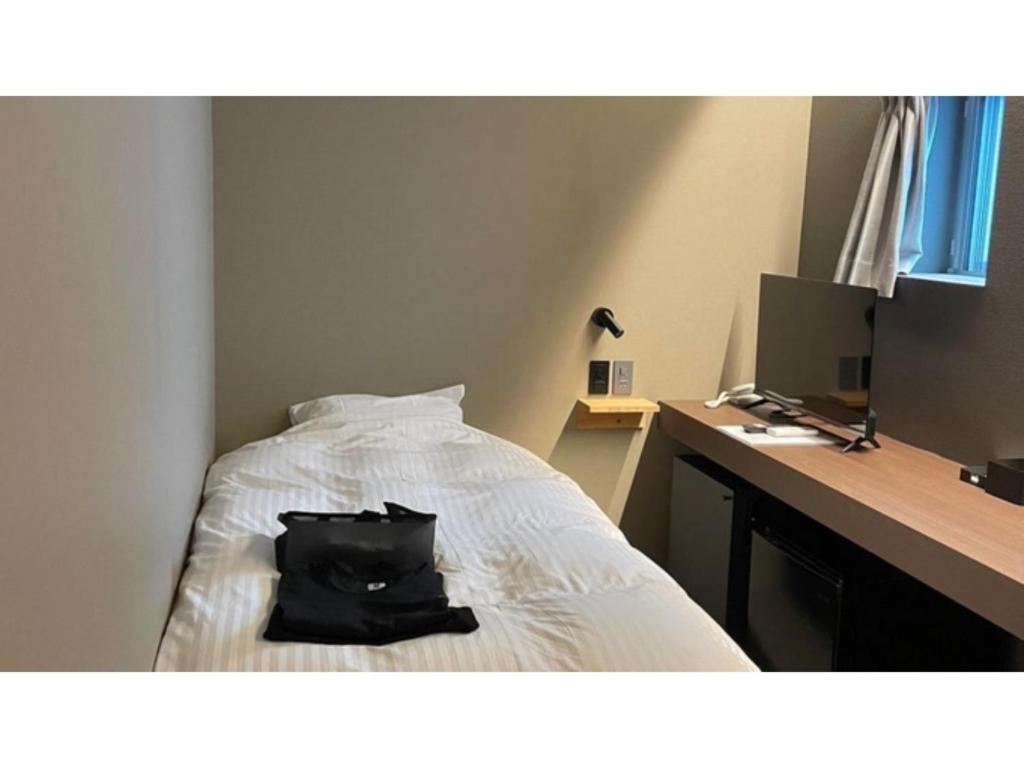 a black bag sitting on a bed with a desk at ＳＡＵＮＡ&ＳＴＡＹ - Vacation STAY 80243v in Setouchi