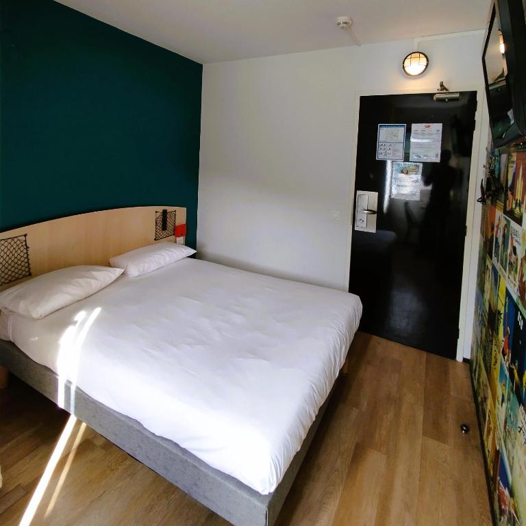 a bedroom with a white bed with a green wall at hotelF1 Lyon Bourgoin-Jallieu in LʼIsle-dʼAbeau