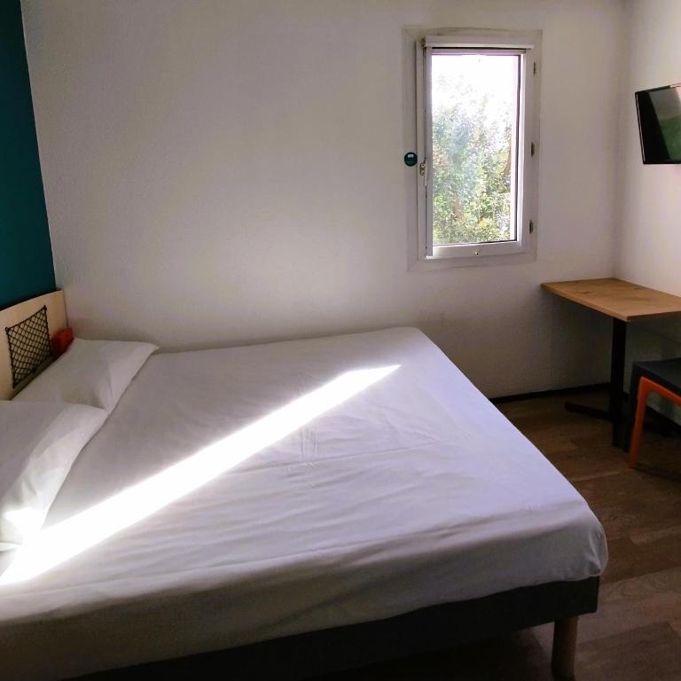 a bed in a room with a window at hotelF1 Lyon Bourgoin-Jallieu in LʼIsle-dʼAbeau