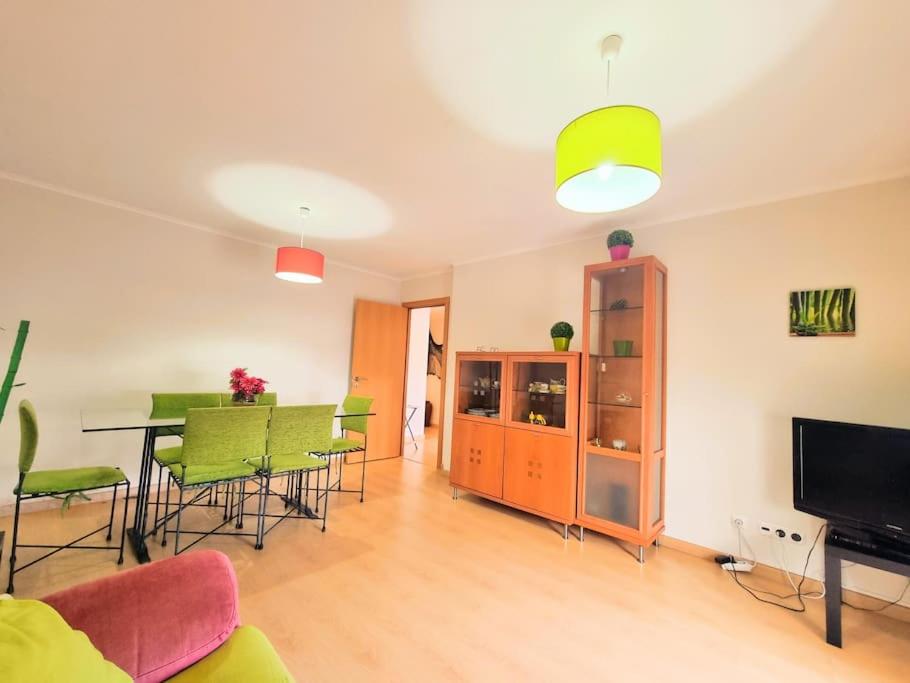 un soggiorno con tavolo da pranzo e sedie verdi di Apartamento Sol e Praia - T2 na Praia de Monte Gordo a Monte Gordo