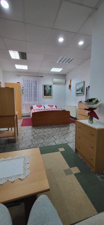 a living room with a bed and a desk and a table at Soba Kolovrat in Straža