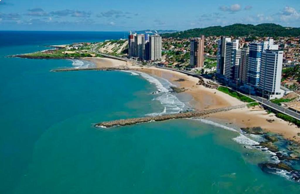 una vista aérea de una playa con edificios y el océano en Seu lugar em Natal, en Natal