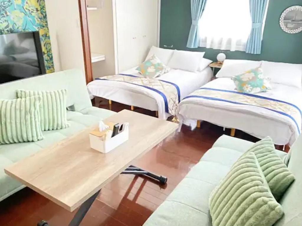 a living room with white couches and a wooden table at Regalia Hills Shibuya Dogenzaka - Vacation STAY 15550 in Tokyo