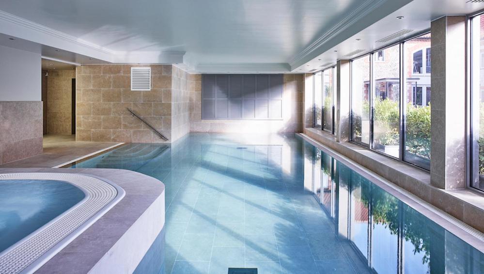 een groot zwembad met een bad in een gebouw bij The Harper in Langham