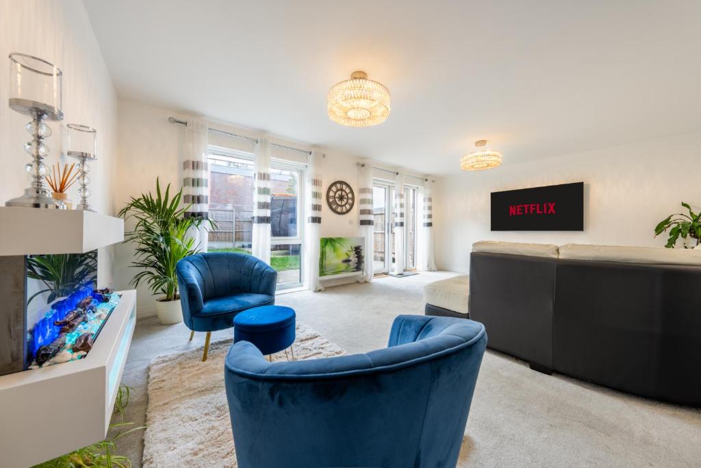 een woonkamer met blauwe stoelen en een bank bij 3 bedroom house in Bricketwood St Albans in Garston
