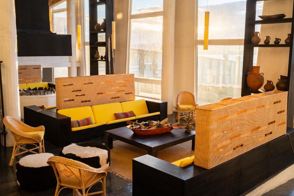 a living room with yellow and black furniture at Remota Patagonia Lodge in Puerto Natales