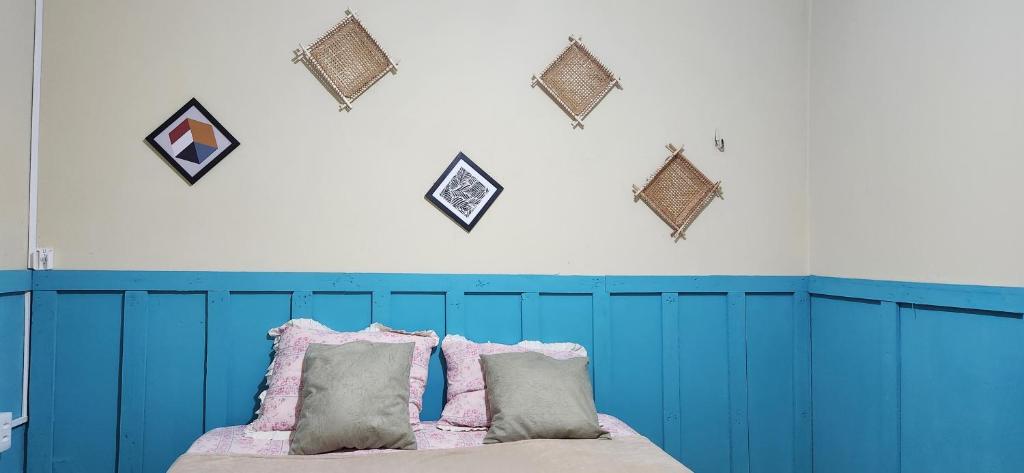 um quarto com uma cabeceira azul e almofadas numa cama em Linda casa com exc. localização em Castanhal