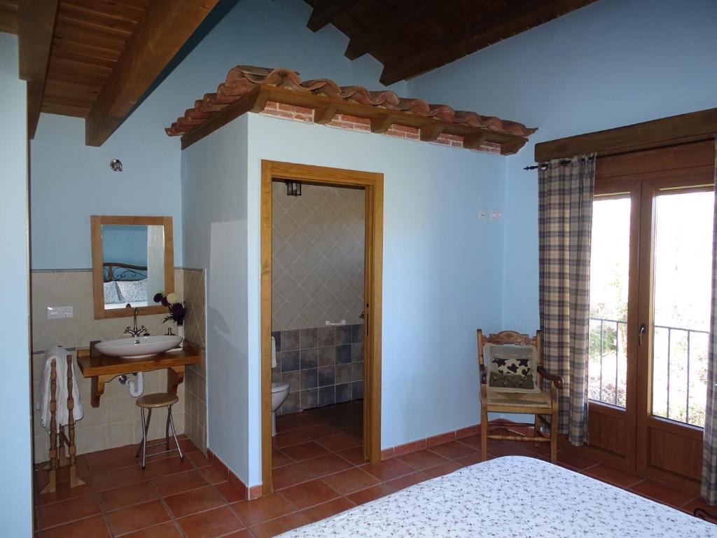 a bedroom with a bathroom with a sink and a mirror at El Aravalle, Altillo del Aravalle in Umbrías