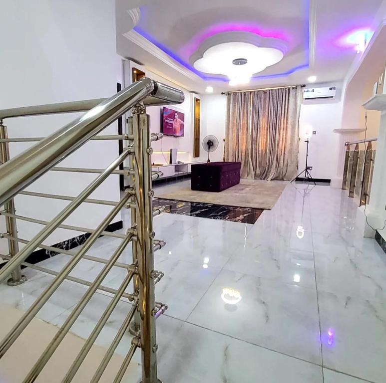 a living room with a staircase and a lobby at Luxurythemain in Ibadan