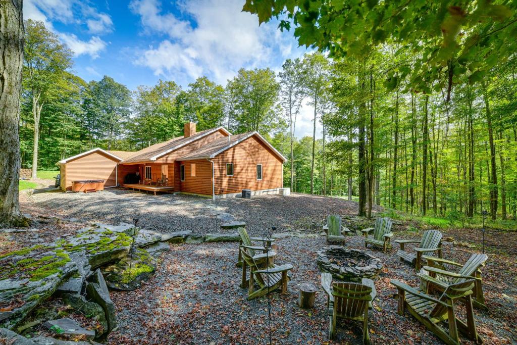 een hut in het bos met picknicktafels en stoelen bij Secluded Union Dale Home about 2 Mi to Elk Mountain! in Pleasant Mount