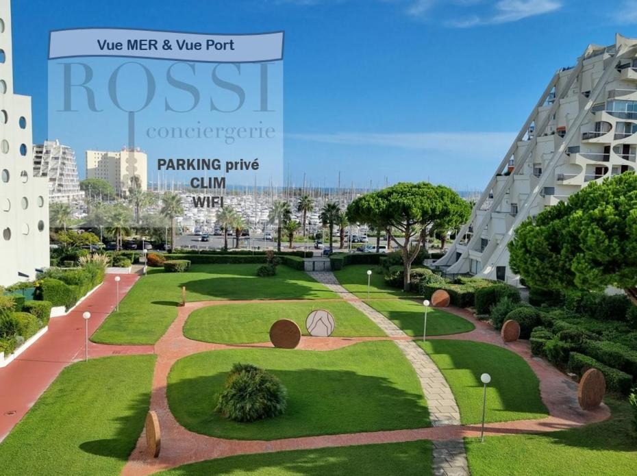 een park in het midden van een stad met een gebouw bij T2 FIDJI vue Port et Mer Parking CLIM Wifi - ROSSIconciergerie - Linge en option in La Grande-Motte