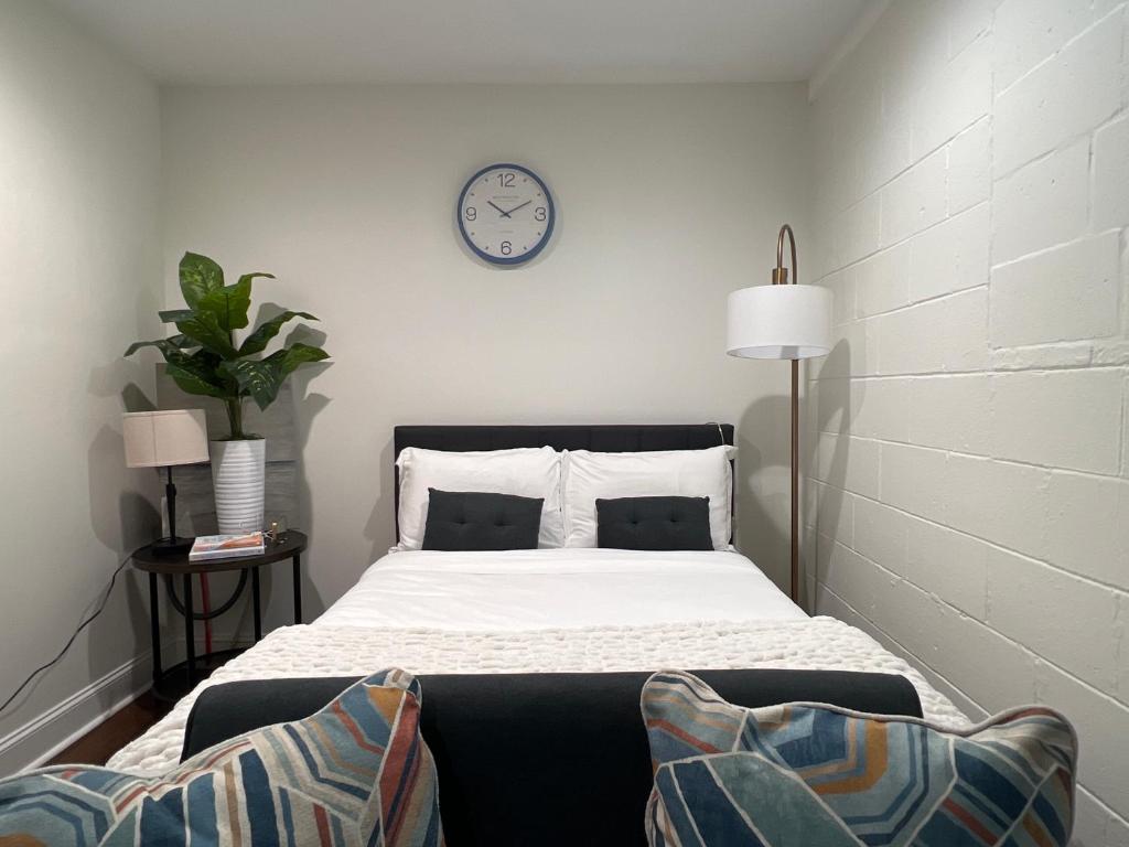 - une chambre avec un lit et une horloge murale dans l'établissement 1BR Fully Handicap Accessible Near Downtown, à Greenville