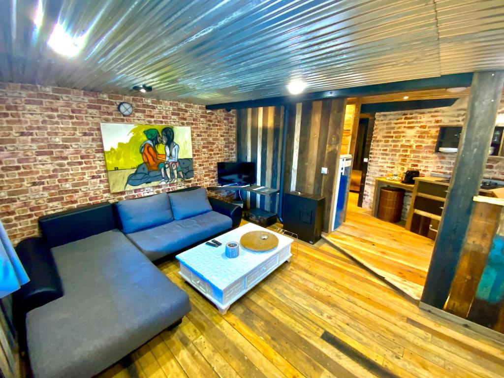 a living room with a couch and a table at Charmant logement en bord de rivière et proche de la gare du Mans in Le Mans