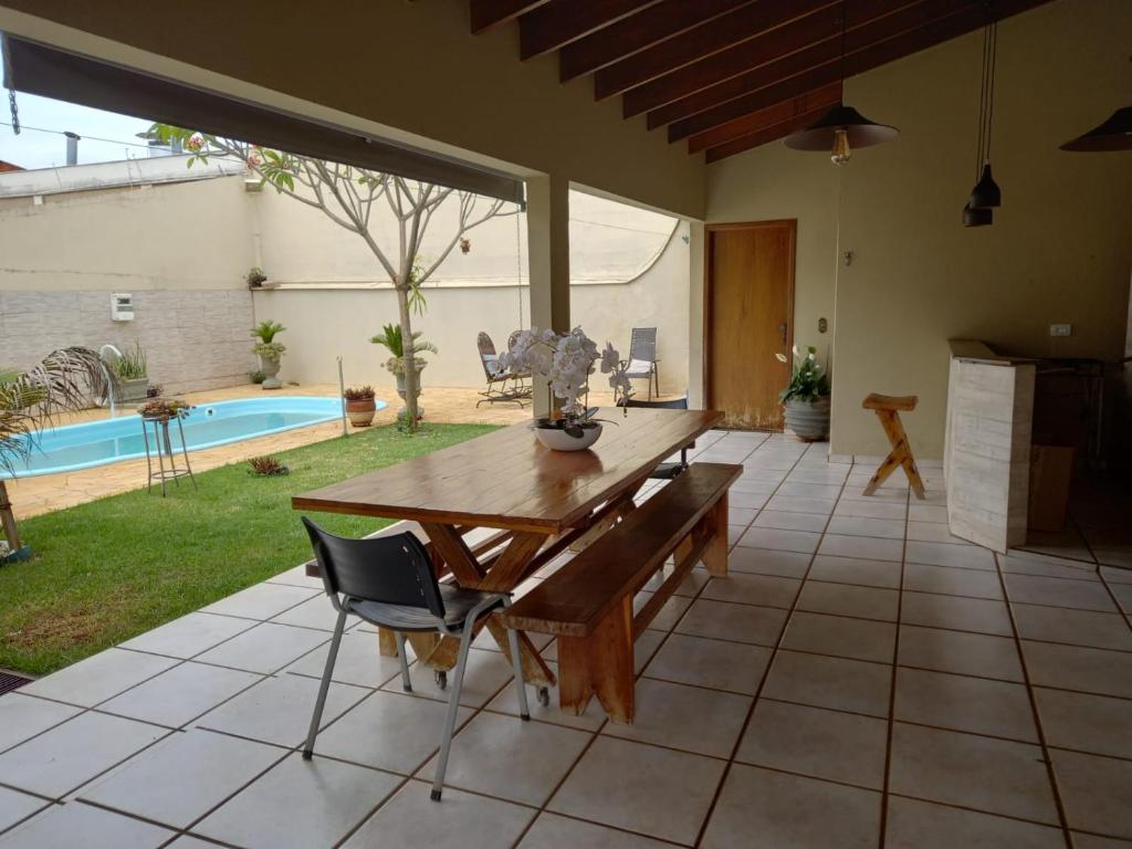 un patio con mesa, sillas y piscina en Aero Hostel Londrina, en Londrina