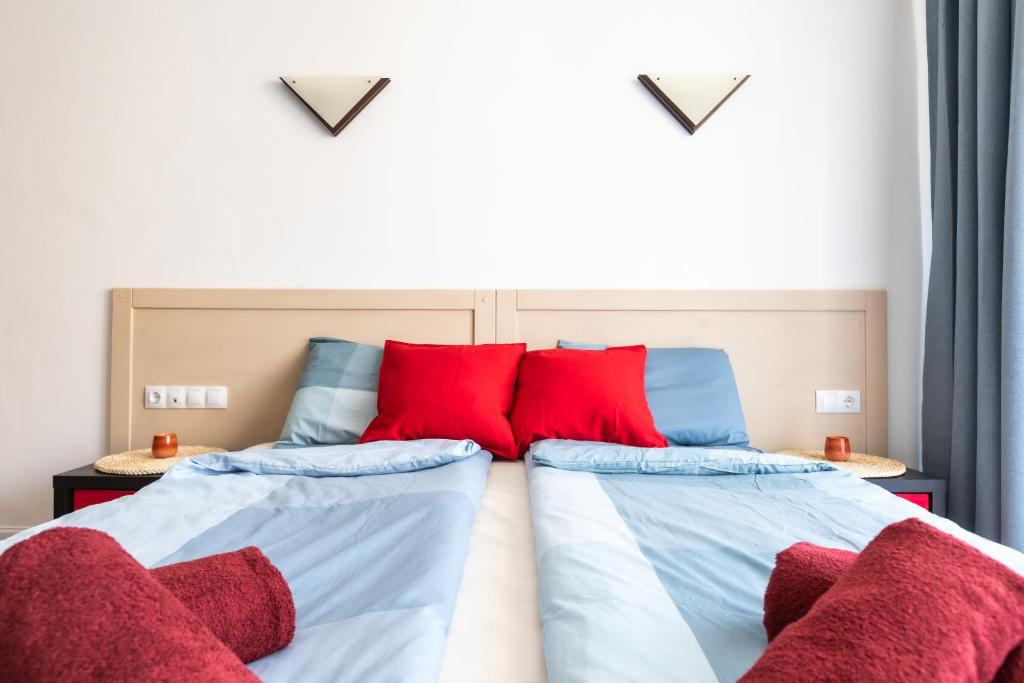 Duas camas com almofadas vermelhas num quarto em Fab studio in 5 min Gondola walk em Bansko