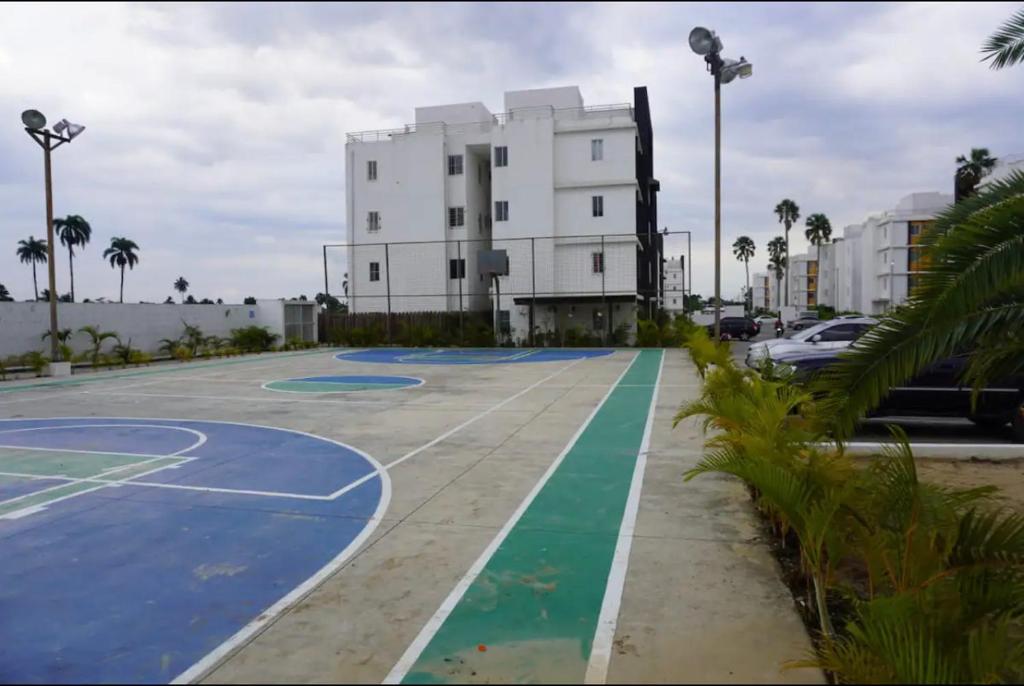 an empty basketball court in front of a building at Hermoso residencial con piscina licey al medio in Licey al Medio