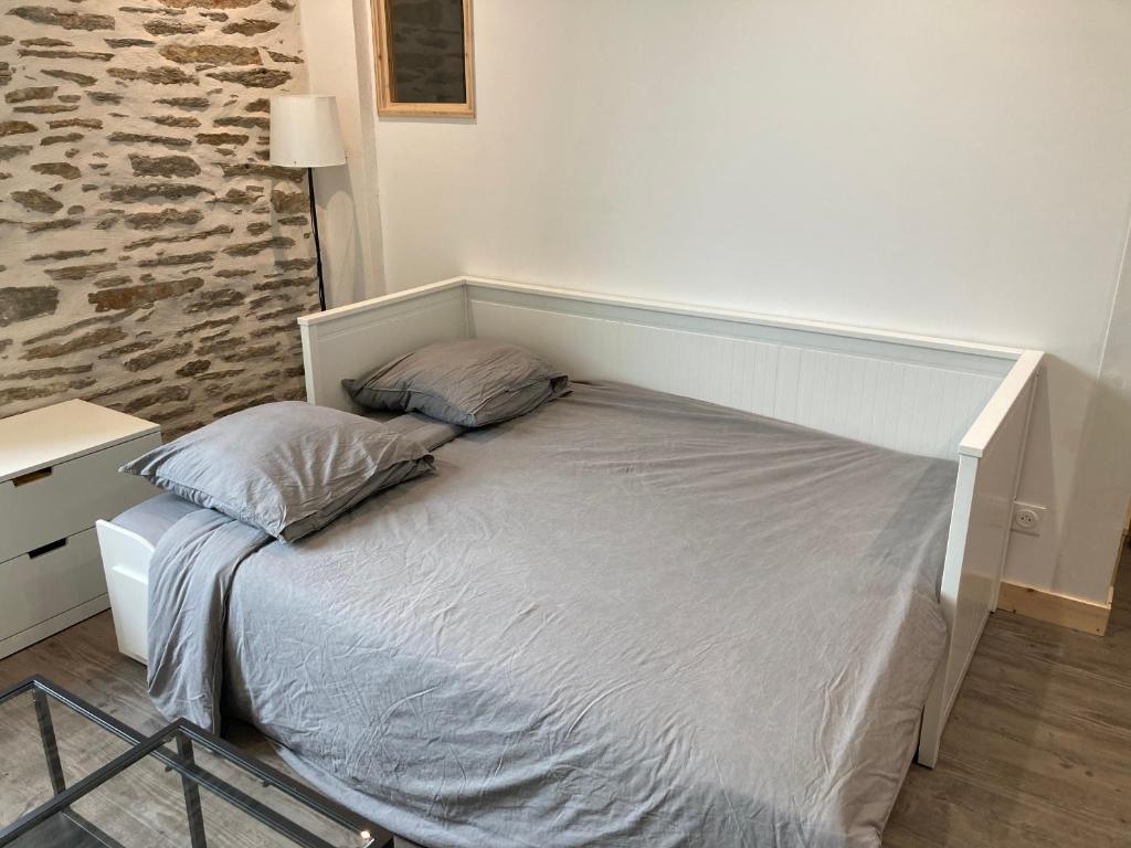 a bed with two pillows on it in a bedroom at T2 Le Conquet &quot;Molène&quot; avec parking privé 300m commerces in Le Conquet