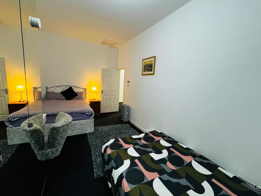 um quarto com uma cama e uma cadeira em Liberty Inn Room with sharing toilet and kitchen em Liverpool