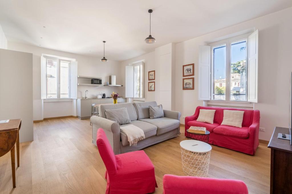 a living room with a couch and two red chairs at Fisher's Apartment in Testaccio in Rome