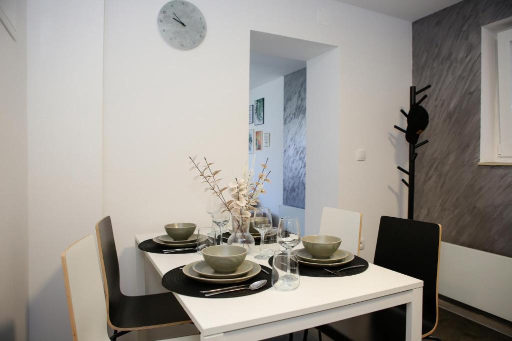 a dining room with a white table and chairs at Apartman Grey in Jastrebarsko