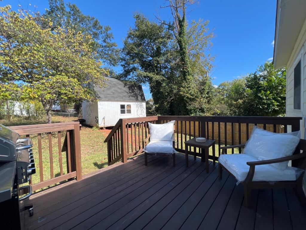 a deck with two chairs and a table on it at 5BR 4B Huge Space with 2 Level Game Barn in Greenville