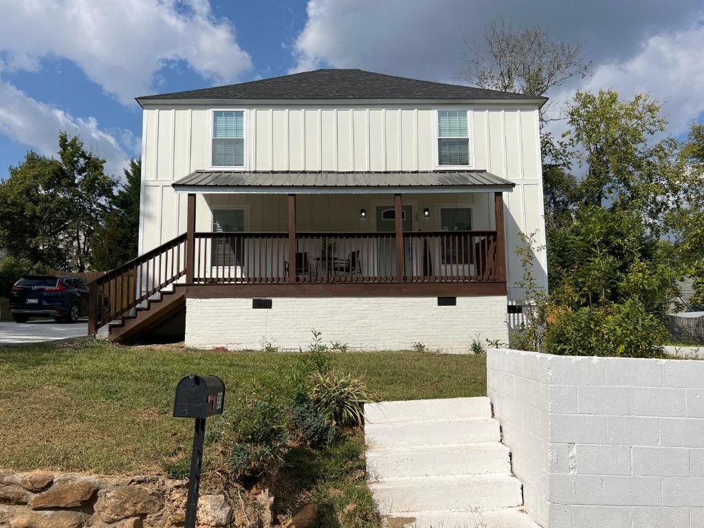 a white house with a porch and a deck at 5BR 4B Huge Space with 2 Level Game Barn in Greenville