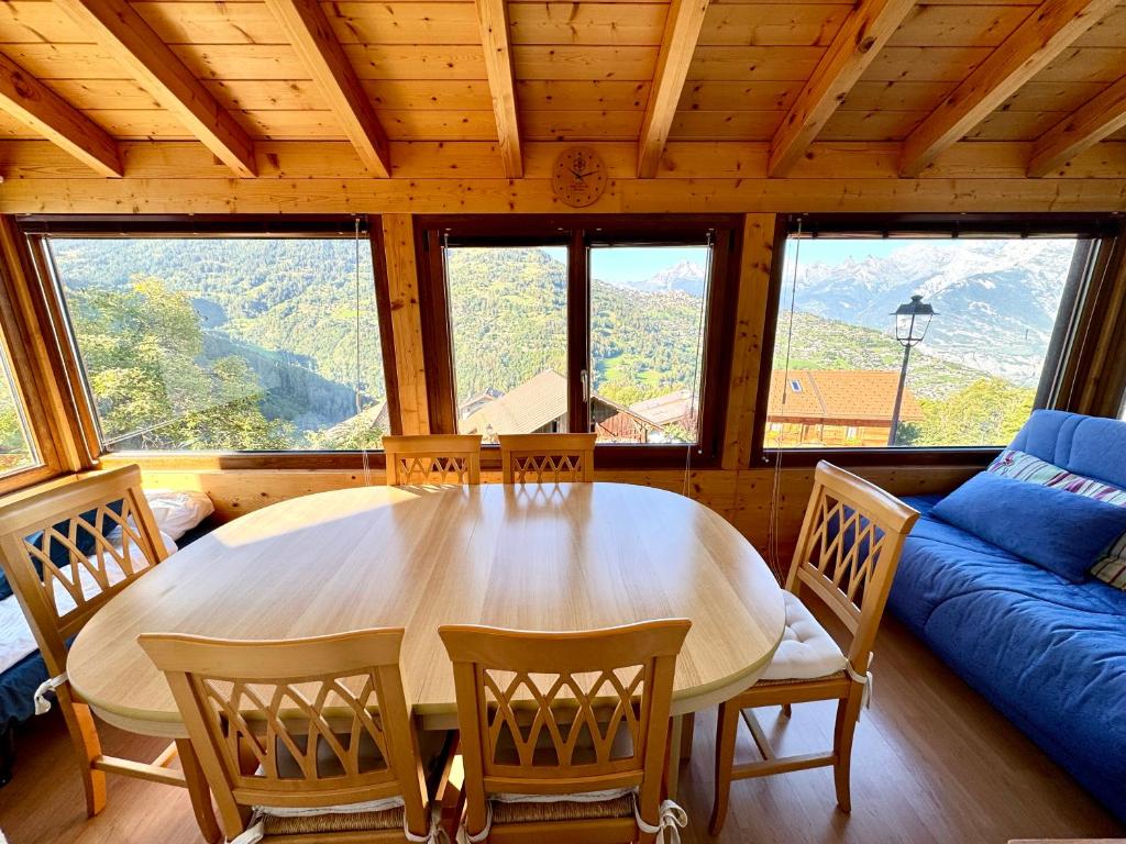 una sala da pranzo con un grande tavolo e sedie di Rue de la Chapelle 24, 1993 Nendaz, Switzerland a Veysonnaz