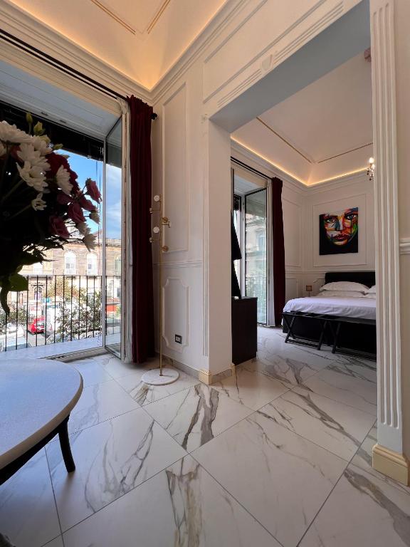 ein Schlafzimmer mit einem Bett und einem großen Fenster in der Unterkunft Ricci Palace Suites in Catania