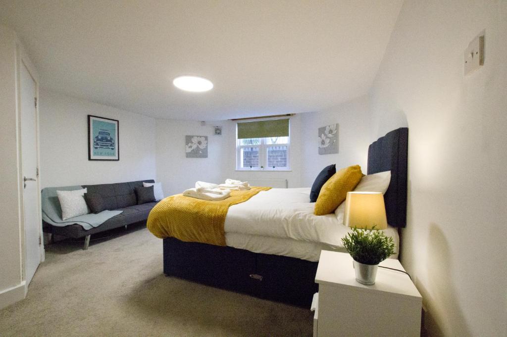a bedroom with a large bed and a couch at 2 Bedroom Flat - Free Parking - Close to Beach in Portsmouth