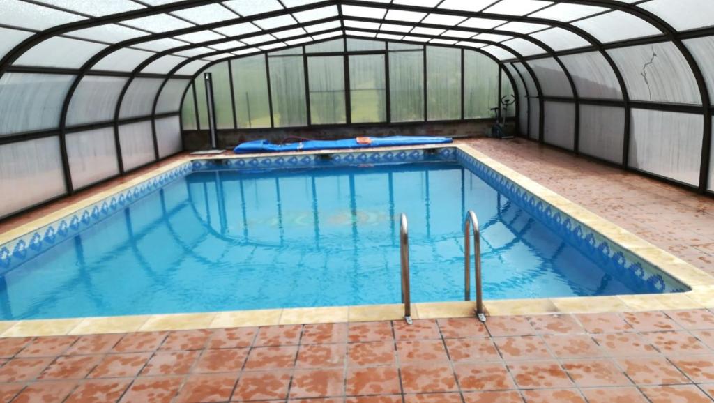 an indoor swimming pool with a glass ceiling at Casa Rural Landa in Galbarra