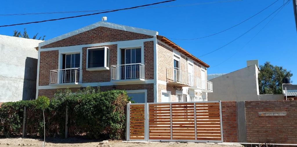una casa di mattoni con una recinzione di fronte di Las Grutas Star a Las Grutas