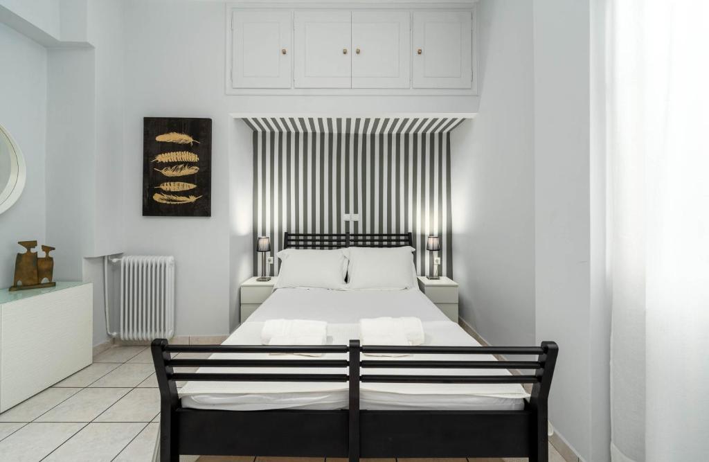 - une chambre avec un lit noir et blanc dans l'établissement Angelica apartment, à Aigio
