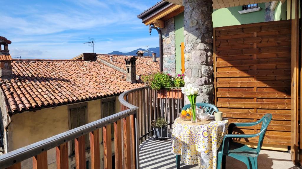 een balkon met een tafel en stoelen op een terras bij La casa nel borgo Mountain Lake Iseo Hospitality in Bossico
