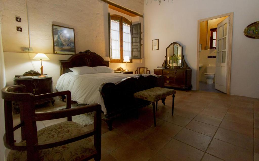 a bedroom with a large bed and a chair at La Trapería Hostal - Pensión con encanto in Benavente