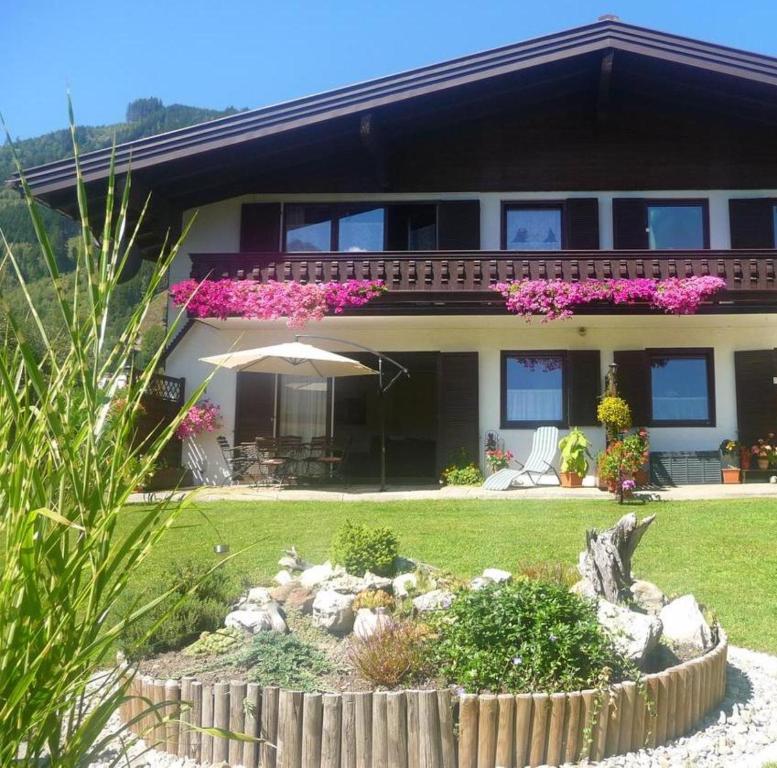a house with an umbrella in front of a yard at Apartment-Alpenfantasie in Zell am See