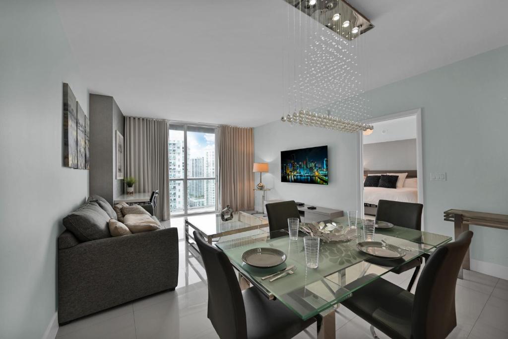 uma sala de jantar e sala de estar com uma mesa de vidro e cadeiras em Perfect One Bedroom at Icon Brickell Amazing views em Miami