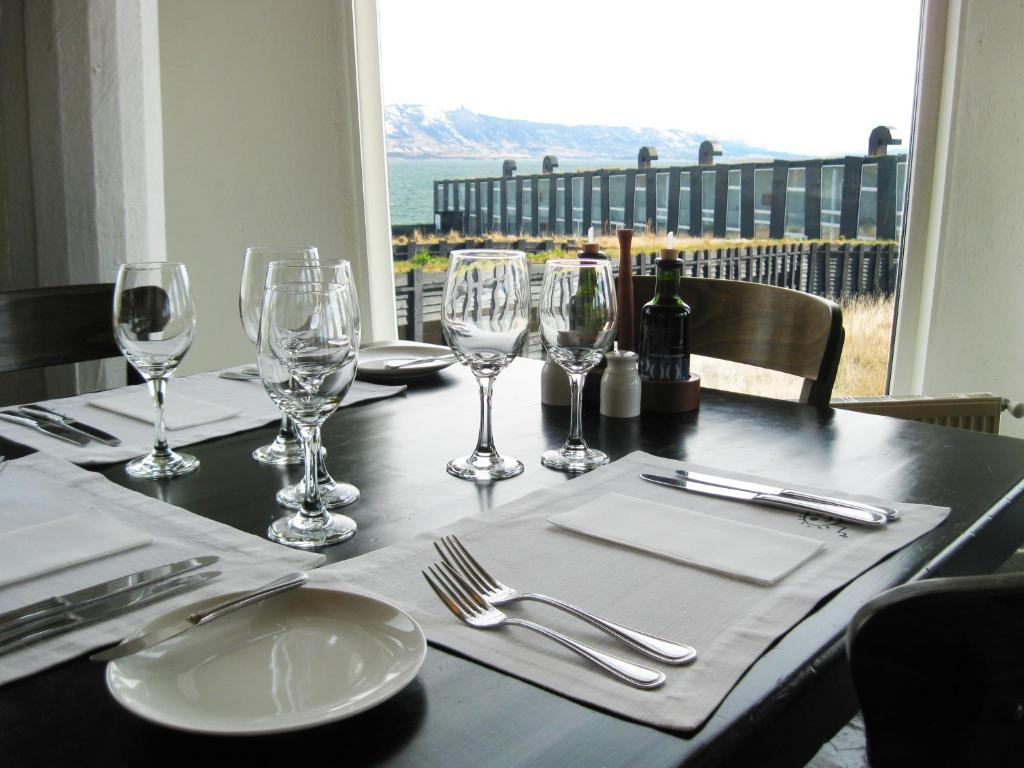a table with wine glasses and a table with a view at Remota Patagonia Lodge in Puerto Natales