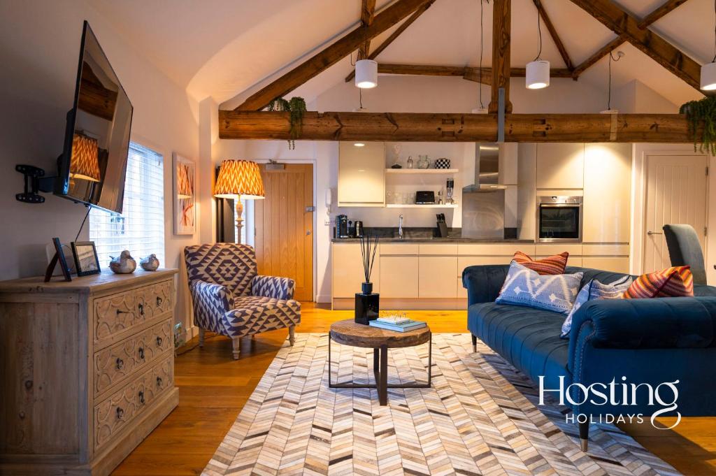 亨利昂泰晤士的住宿－The Penthouse, Henley-On-Thames，一间带蓝色沙发的客厅和一间厨房