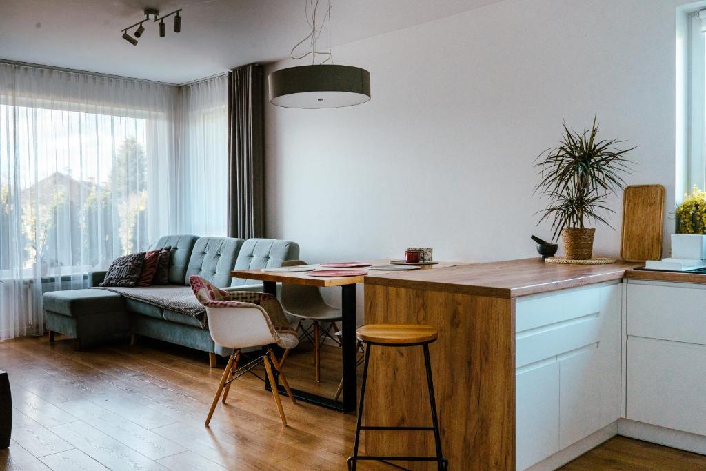 a kitchen with a table and a living room at Rest In Sanok Apartment in Sanok