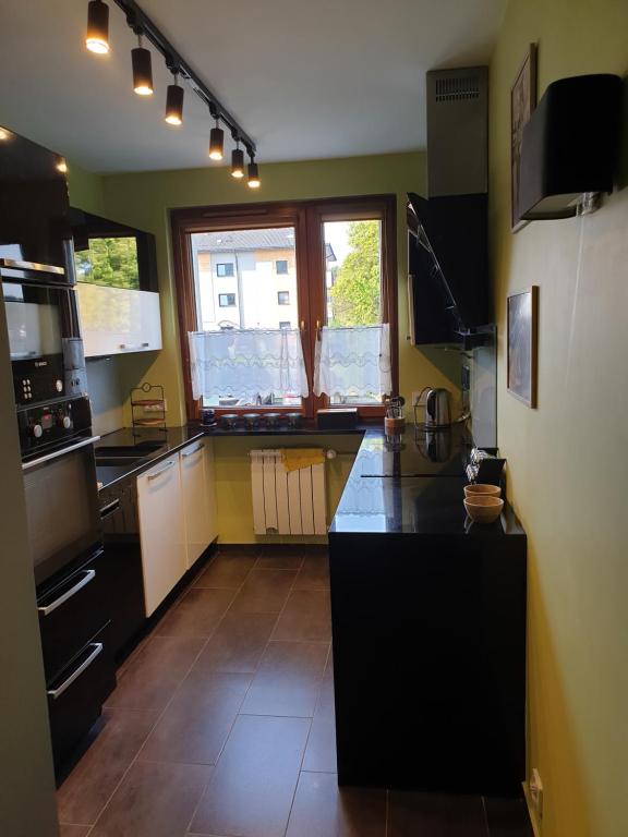une cuisine avec un comptoir noir dans une pièce dans l'établissement Przestronny apartament dla 9 osób - 4 sypialnie, PARKING, à Gliwice