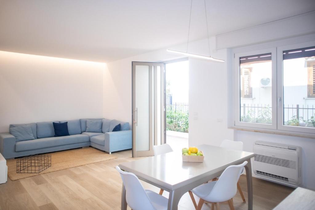 un soggiorno bianco con tavolo e sedie bianchi di Appartamento Elise a Siderno Marina