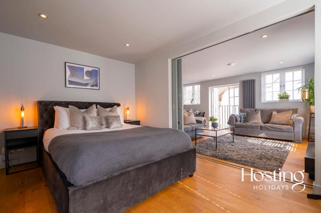 a bedroom with a large bed and a living room at Modern Luxury Apartment In The Heart of Henley in Henley on Thames