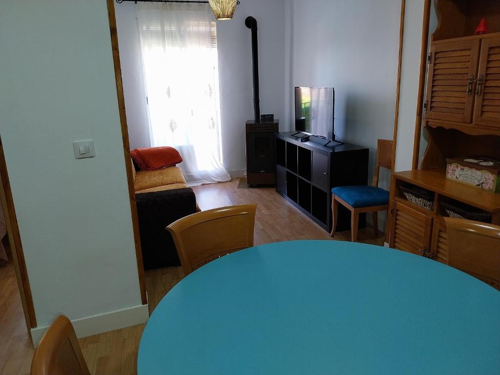 uma sala de jantar com uma mesa azul e cadeiras em Apartamento San Juan em Riaza