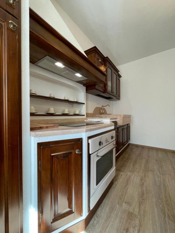 een keuken met houten kasten en een fornuis met oven bij Agriturismo Nonno Dante - Casa Moraiolo in Castiglion Fibocchi