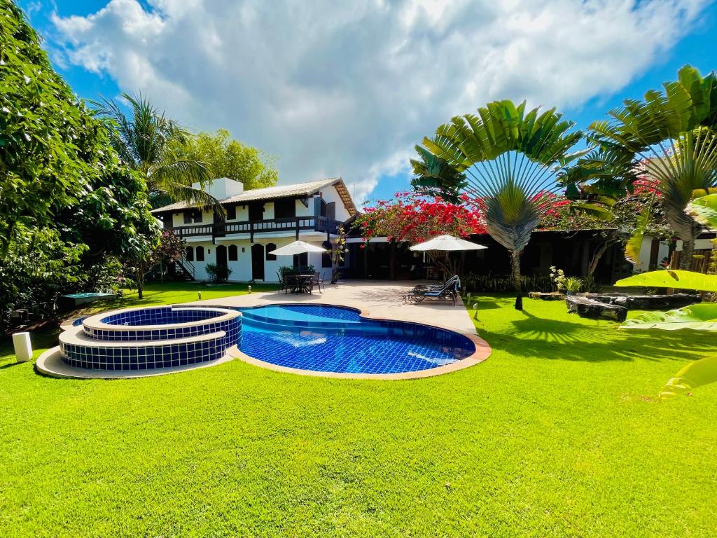 a house with a swimming pool in a yard at Casa da Vila Outeiro das Brisas in Praia do Espelho