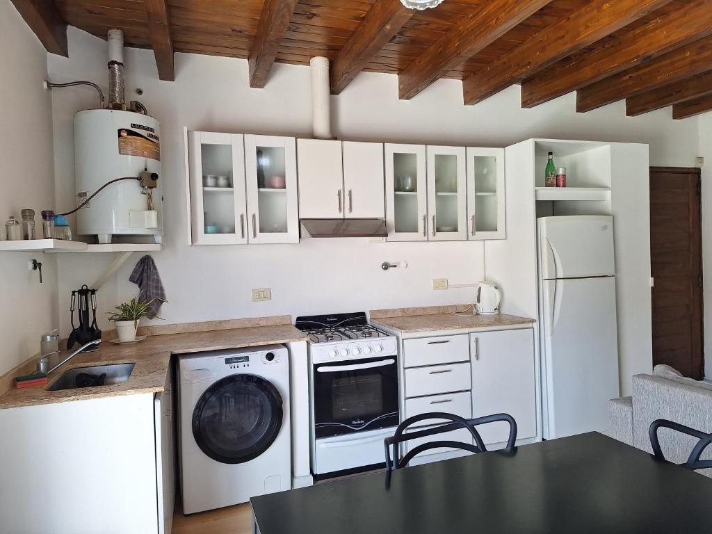 グアイマレンにあるDepartamento de Noahのキッチン(白いキャビネット、洗濯機、乾燥機付)
