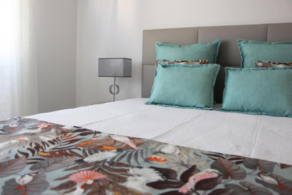 een slaapkamer met een groot bed met blauwe kussens bij ARRUDA LUXURY APARTMENT with AC in Cascais