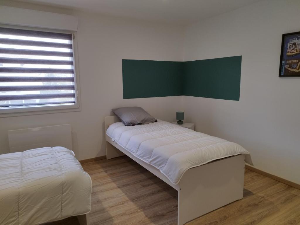 Cette chambre dispose de deux lits, d'une fenêtre et d'un canapé-lit. dans l'établissement Gîte l'harmonie I, à Fraize