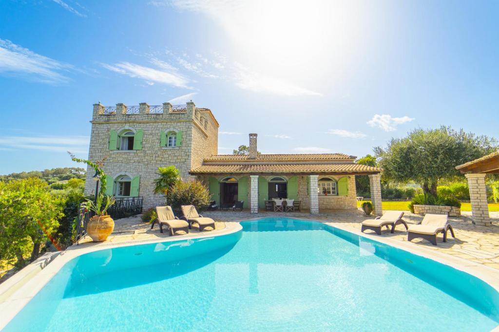 een villa met een zwembad voor een huis bij Villa Emily in Ágios Stéfanos